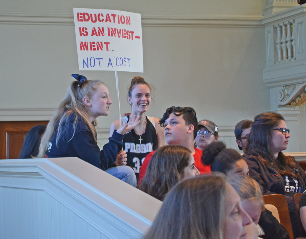 AN INVESTMENT: A student holds up a protest sign at the Monday night meeting of the Warwick City Council.